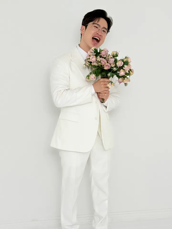 꽃다발을 들고 크게 웃는 신랑